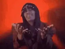 Woman in black hood dancing with red background