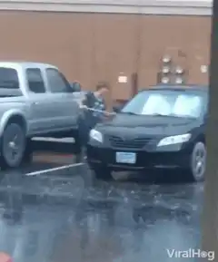 Woman washing car in heavy rain