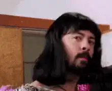 Man in wig and earrings looking confused