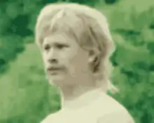 blonde man with mustache looking around