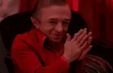 Man in red shirt clapping hands