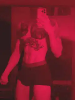 person taking mirror selfie in red light