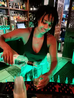 woman pouring drink and laughing