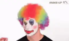 Person putting on clown makeup and red nose