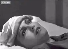 Woman crying in bed with hand on forehead