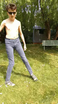 Shirtless man dancing in park