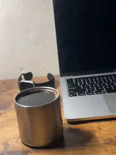 Coffee cup on desk next to laptop
