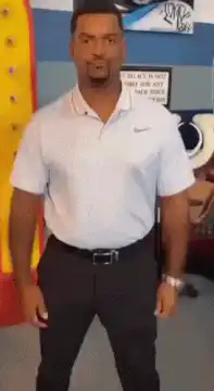 Usher dancing in a white polo shirt