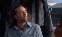 Nicolas Cage smiling in a car