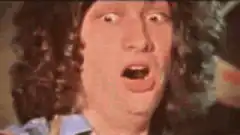 Man with curly hair making shocked face