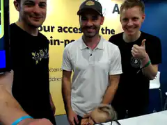 Three men posing with a baby