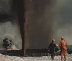 Firefighters watch a geyser erupt into a massive fireball
