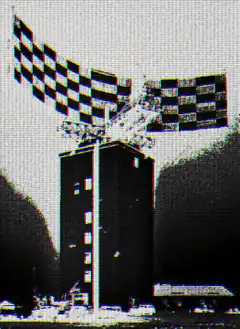 Checkered flags waving over a tower