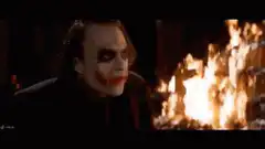 Joker laughing in front of burning money