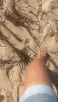 First person walking on sandy beach