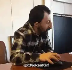 Man laughing and waving at computer