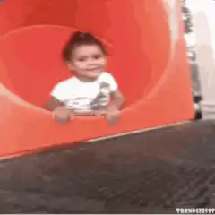 Baby slides down red tube slide