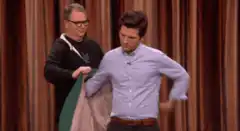 Man puts on jacket with help
