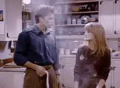 Man and woman covered in flour in kitchen