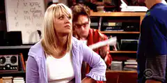 Penny looks up while Raj waves paper