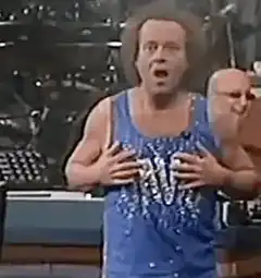 Carrot Top singing with hand on chest