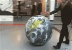Man kicks globe across floor