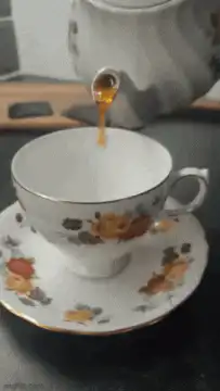 pouring tea into floral cup