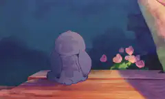 Sad Stitch sitting on a wooden deck