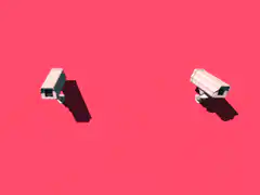 Two security cameras on pink background