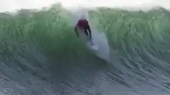 Surfer riding inside a barrel wave
