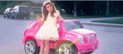 girl in pink toy car giving thumbs up