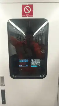 Man in orange jumpsuit reflected in door window