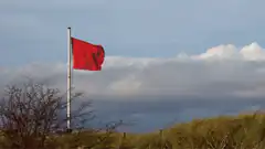 Red flag waving on a pole