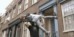 man throws woman over brick building