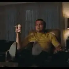 Leonardo DiCaprio pointing while holding a mug