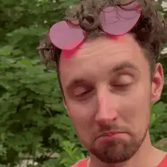 man with pink glasses on head making faces