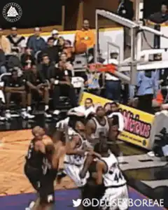 basketball player dunks over defender
