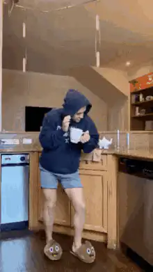 Person in hoodie dancing with mug