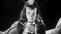 Vampire woman drinking from a goblet