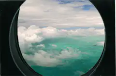View from airplane window above clouds