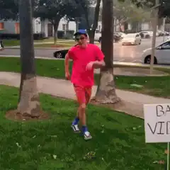 Man running past bad vibes sign