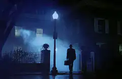 Man in hat and coat under streetlamp