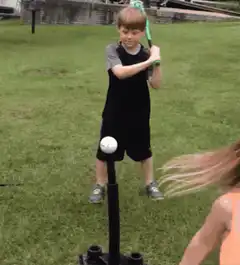 Boy misses tee ball swing