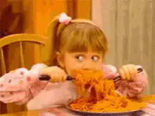 Girl eating spaghetti with wide eyes