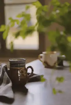 steaming mug on table with plant