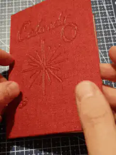 Hands opening a red embossed calendar