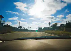 Car driving down a sunny road