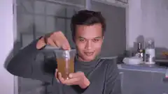 Man stirring drink with a smile