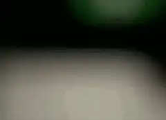 blurry green light on white surface