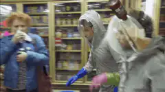 Two people in hazmat suits dancing in a store